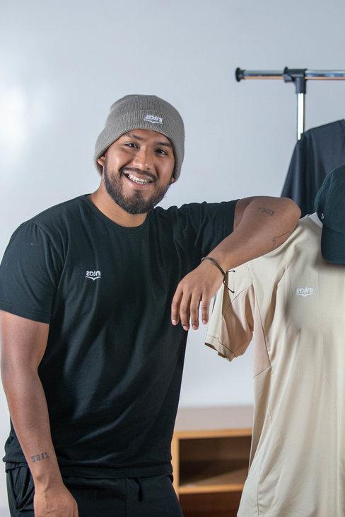 Diego Alonso Cruz Diaz standing next to sport clothing that he designed